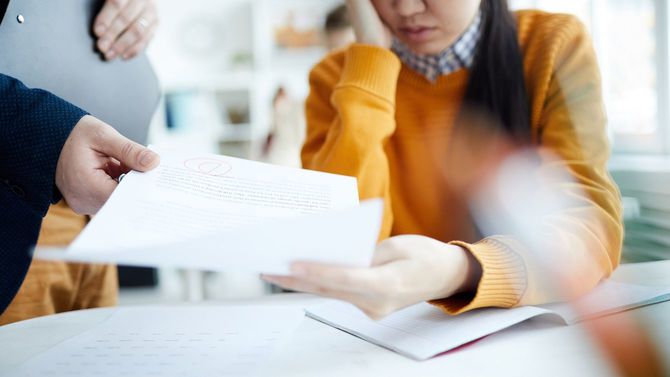 悪い点数のテスト用紙を受け取る女生徒