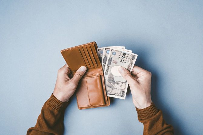 財布からお金を払う人の手