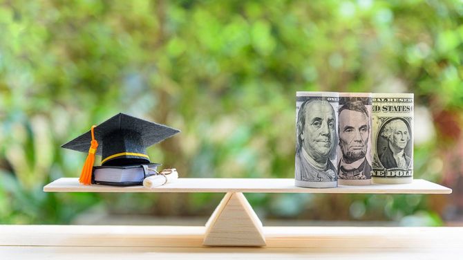 卒業帽と卒業証書の反対側には紙幣が載せられた天秤