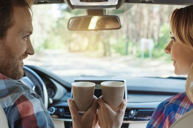車内でコーヒーを飲むカップル