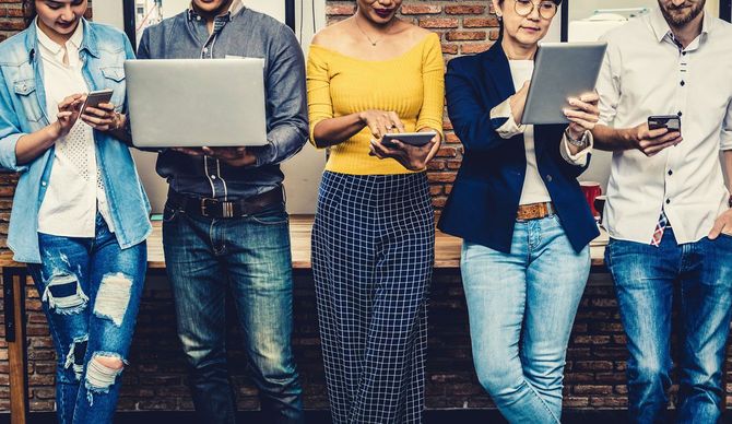 スマホやタブレット、ノートパソコンを使用して仕事をする人たち