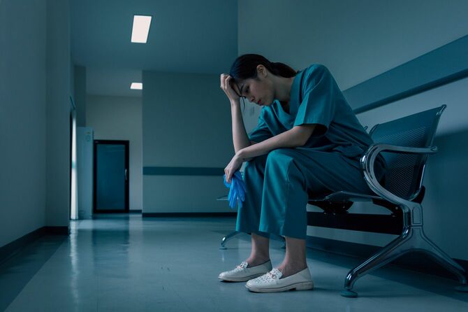 廊下の椅子に座る疲労した医療看護師