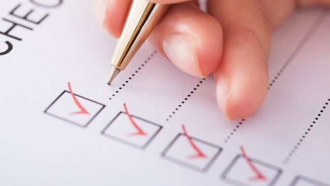 チェックリストを作成する女性の手元