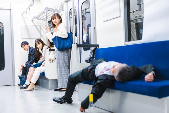 電車の中で酔っ払うビジネスマン