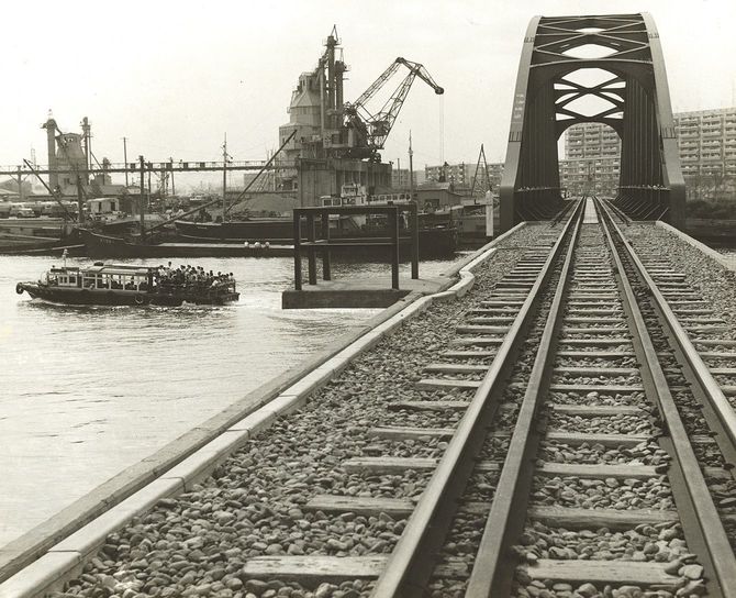 現役当時の晴海鉄道橋。豊洲側から見た晴海の風景。奥に晴海団地とセメント工場が見える(中央区立京橋図書館蔵「晴海橋附近」1962年頃)
