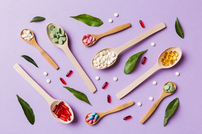 木製のスプーンにそれぞれ錠剤やカプセルなどの栄養補助食品がのっている