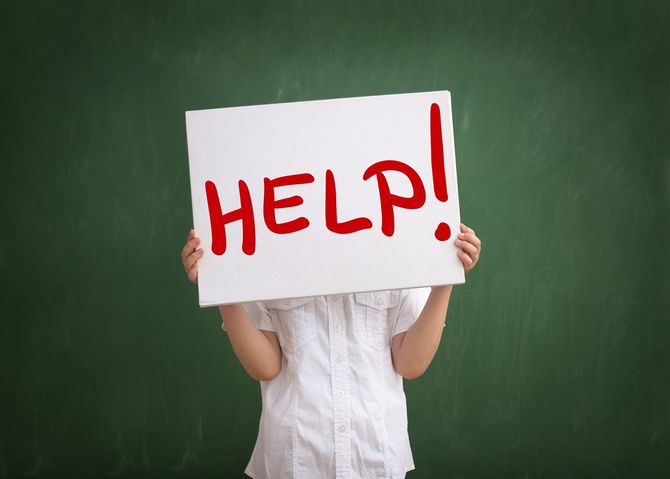 「HELP！」と書かれたボードを持つ人