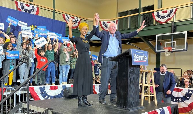 イルハン・オマル下院議員の手を取るサンダース候補