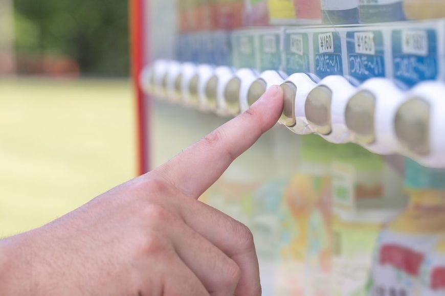 自動販売機でペットボトル飲料を購入する手元