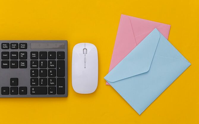 電子メール。黄色の背景にPCキーボードと封筒。