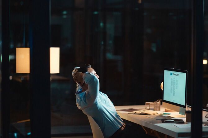 深夜の仕事中に机の上でリラックスしているビジネスマン