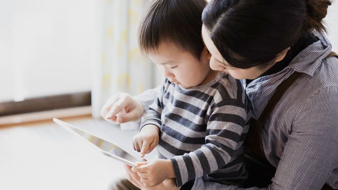 母と息子が一緒にタブレットを使用している