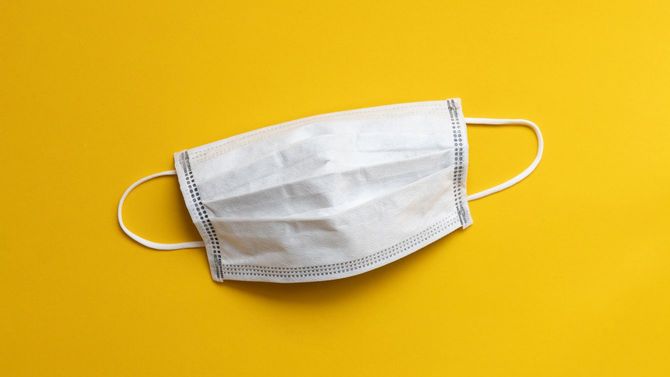 黄色の背景に医療使い捨てマスク