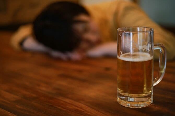 酒を飲んで眠る女性