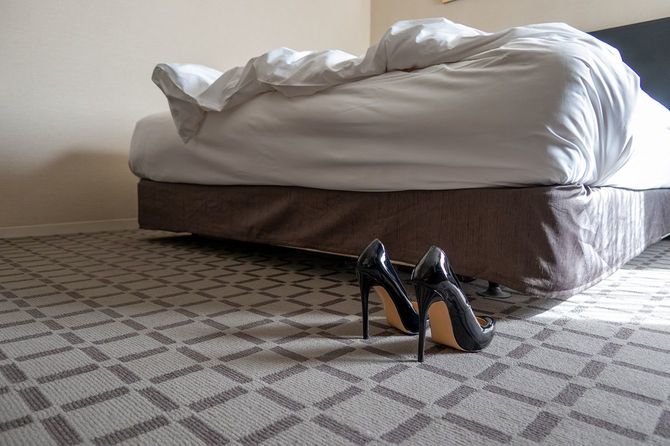 ベッドルーム内の黒い光沢のあるハイヒール