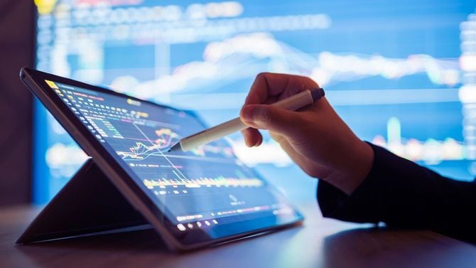 タブレット端末で株式市場データを見る女性