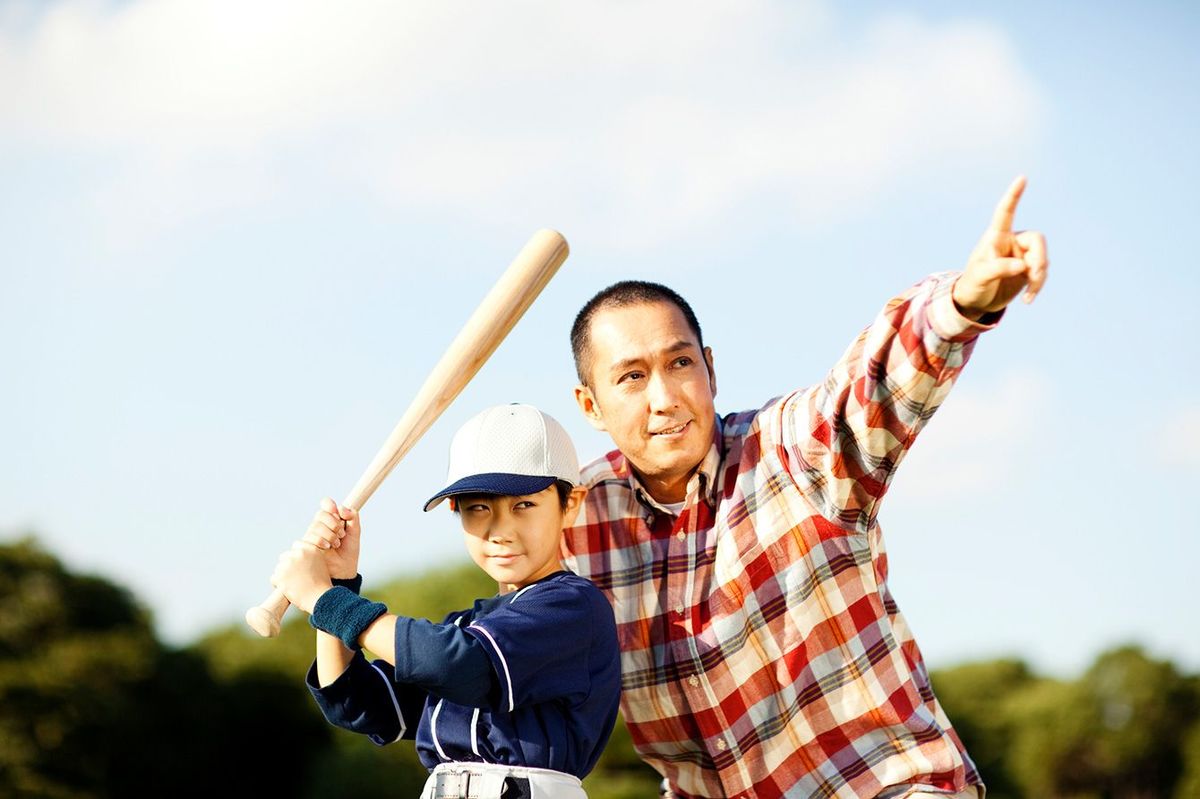 子供に野球を教える父親