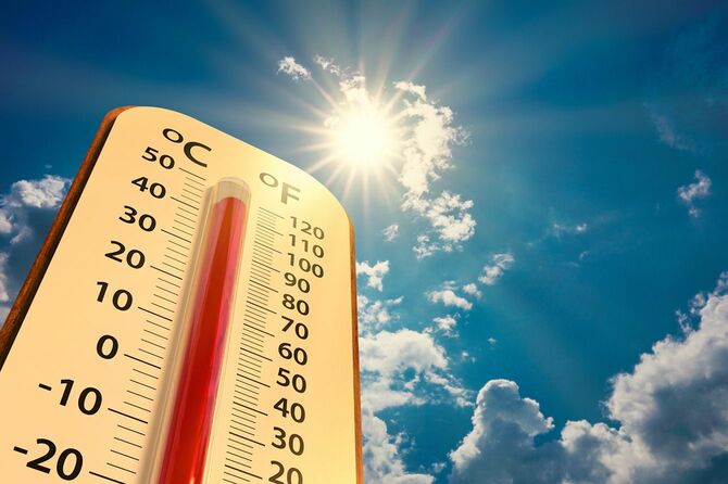 太陽が輝く空と高温を示す温度計