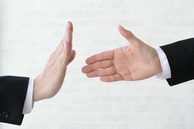 手のジェスチャーによる握手拒否