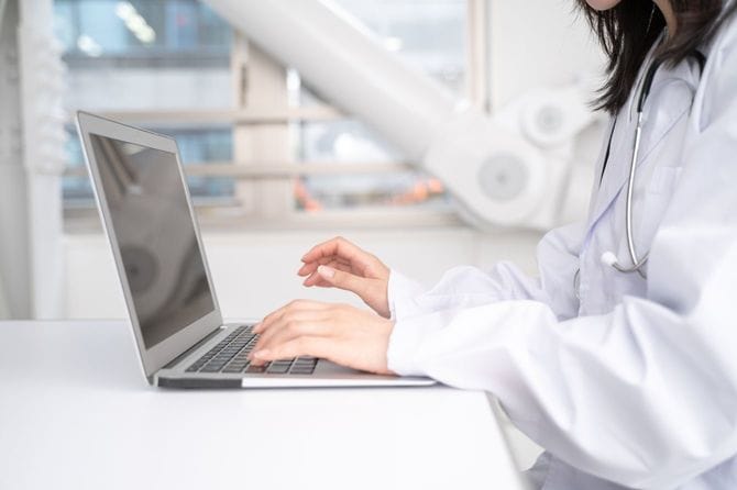 白衣でPCを使用している女性医師