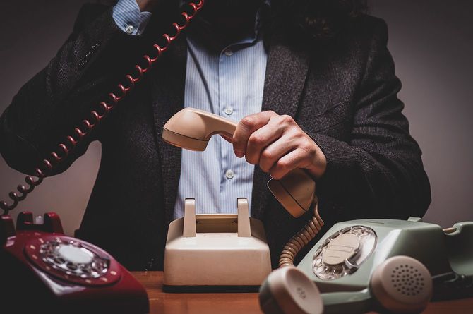 たくさんの電話に対応する男性