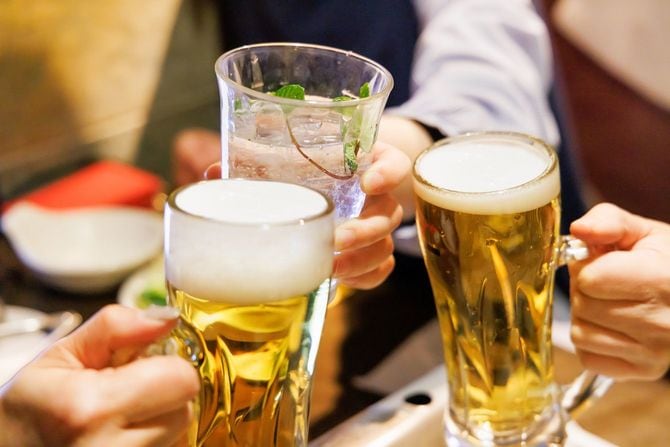 レストランでビールとサワーで乾杯する人々