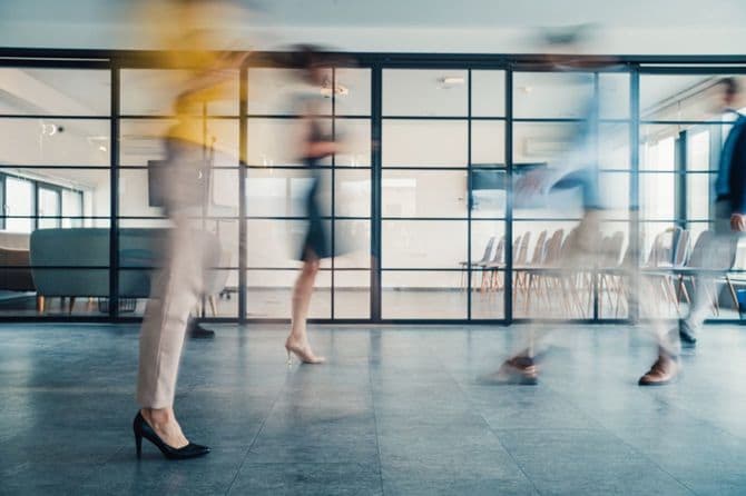 忙しいオフィスを行き交う人々