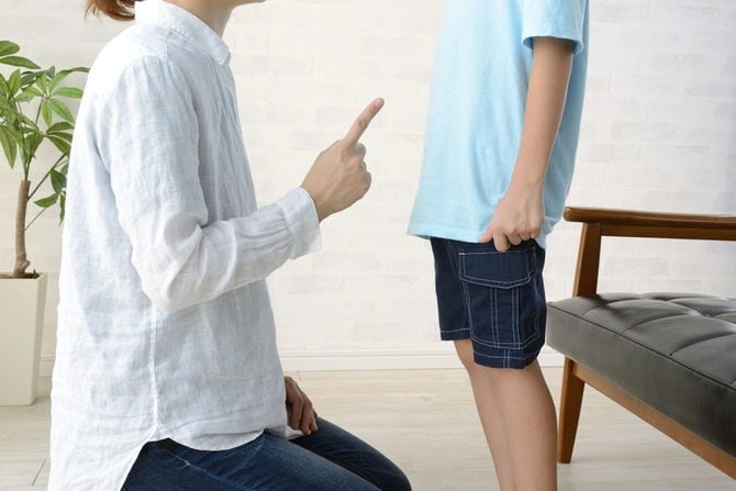 居間で息子を叱る母親