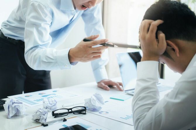 同僚に叱責されるビジネスマン