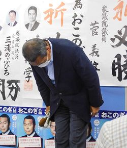 対立候補の当選確実の連絡が入り、支援者らに頭を下げる小此木八郎氏＝2021年8月22日、横浜市