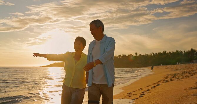 海岸沿いを歩く夫婦