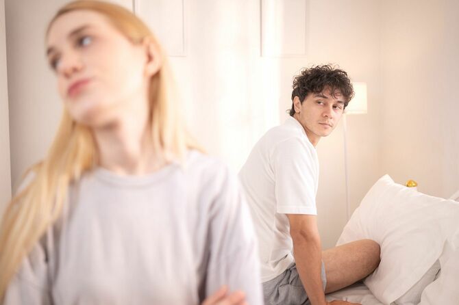 寝室でお互いに苦い顔をする夫婦