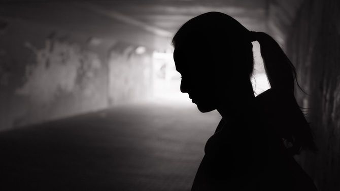 暗いトンネルでうつむく女性