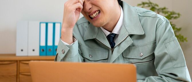 デスクワークに疲れた男性労働者
