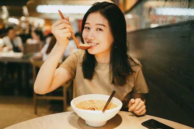 日本のラーメンを食べる女性