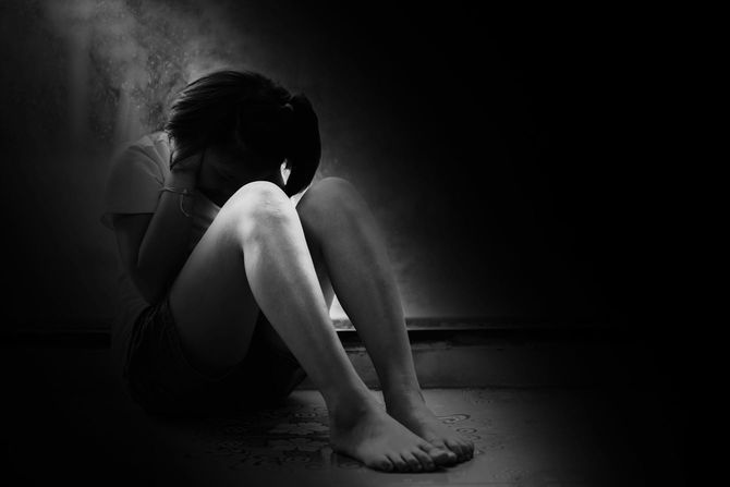 座り込んで耳をふさぐ子供