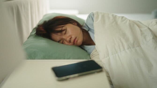 疲れてベッドに寝る人