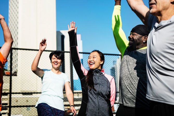 笑顔で手を上げるさまざまな人種の仲間たち