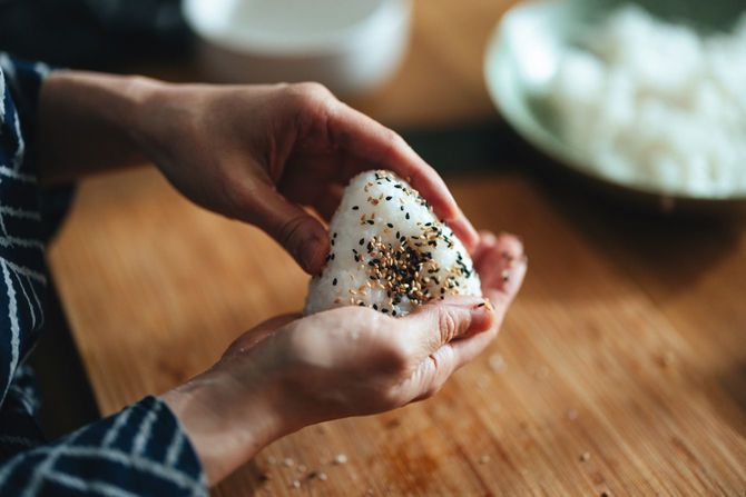 自宅でおにぎりを準備する女性の手