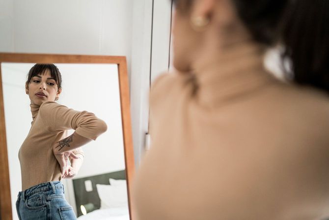 鏡で自分の姿をチェックする女性