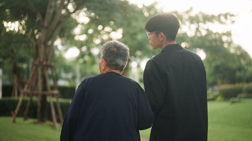 青年と公園でくつろぐお年寄り