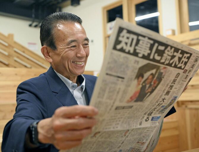 静岡県知事選での初当選から一夜明け、新聞を手にする鈴木康友氏＝2024年5月27日午前、浜松市