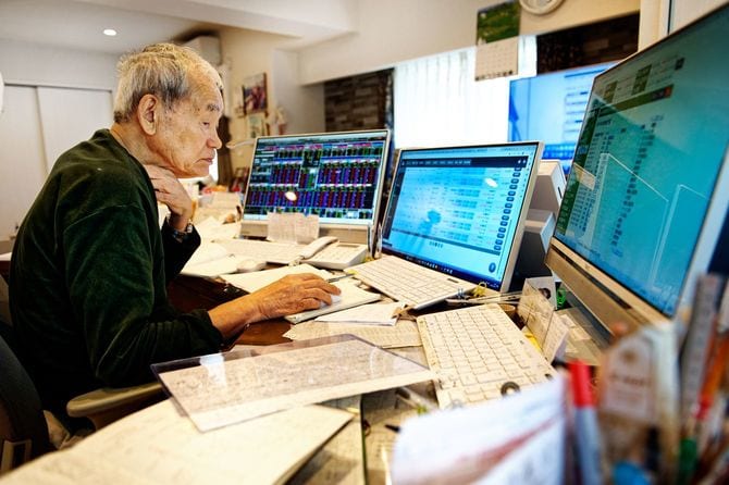 自宅で3つのモニターに向かうシゲルさん