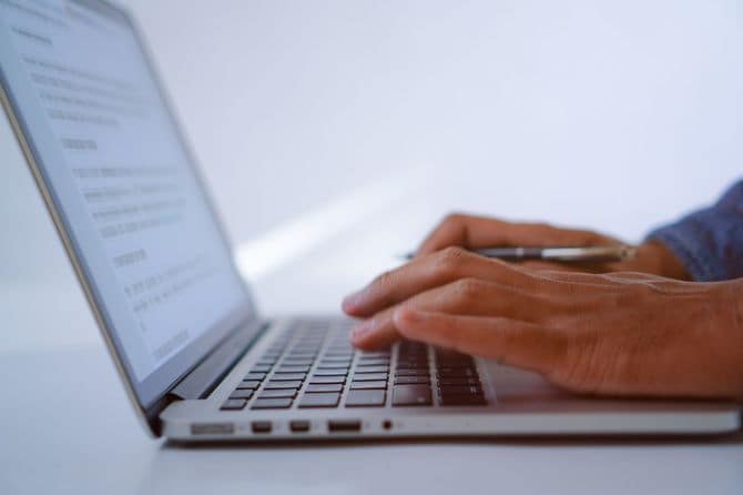 ノートパソコンのキーボードに入力する男性