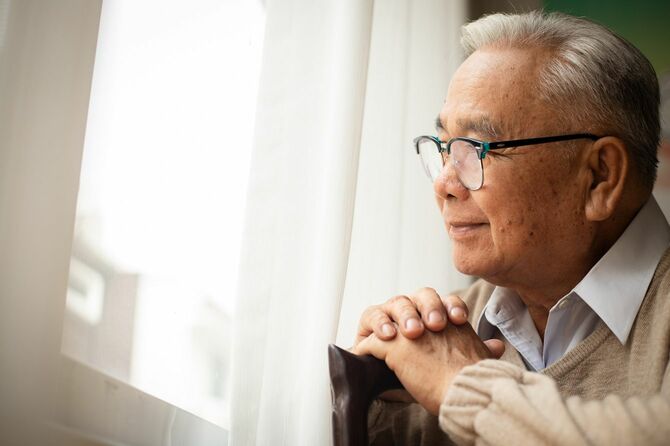 悲しそうに窓の外を見ている老人