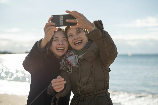 ビーチで自撮りをする母娘