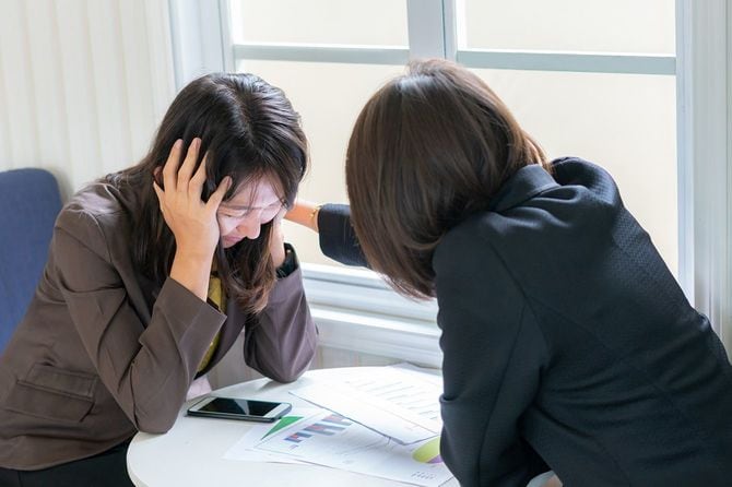 落ち込んでいる同僚を慰める女性