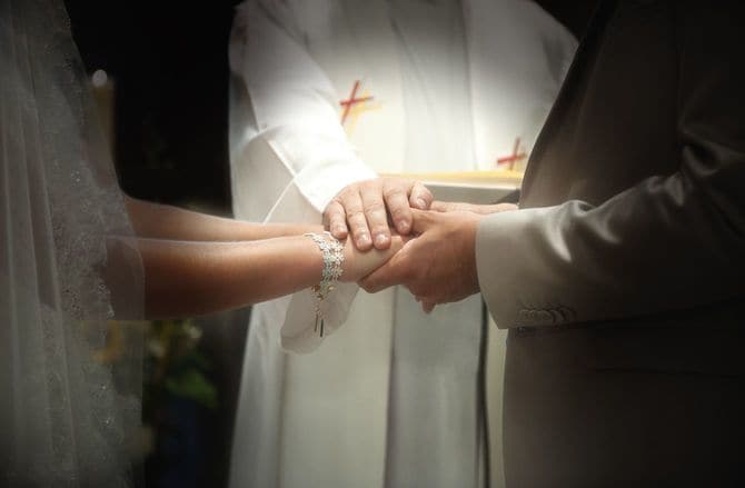 新郎新婦の手に手を重ね、祝福している手元