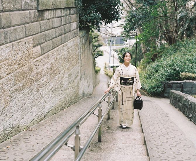 着物を着て坂の途中に立つ女性