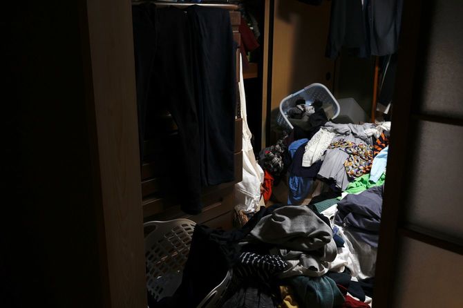 服などが乱雑に積み上げられた部屋